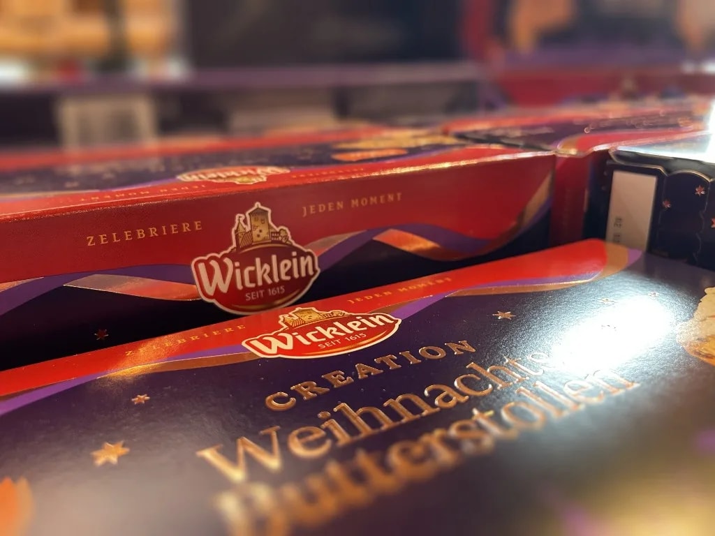 Wicklein Creation Christmas butter stollen on the shelf, moment ribbon and the claim “Zelebriere jeden Moment” on the pack