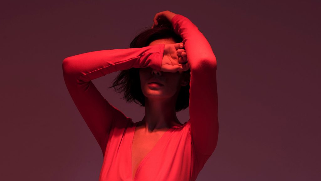 woman in red covering her eyes